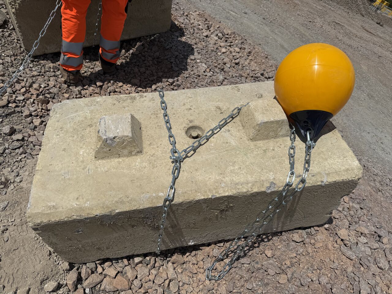 Two tonne concrete anchor block chained to a buoy, used to hold the silt curtain in place