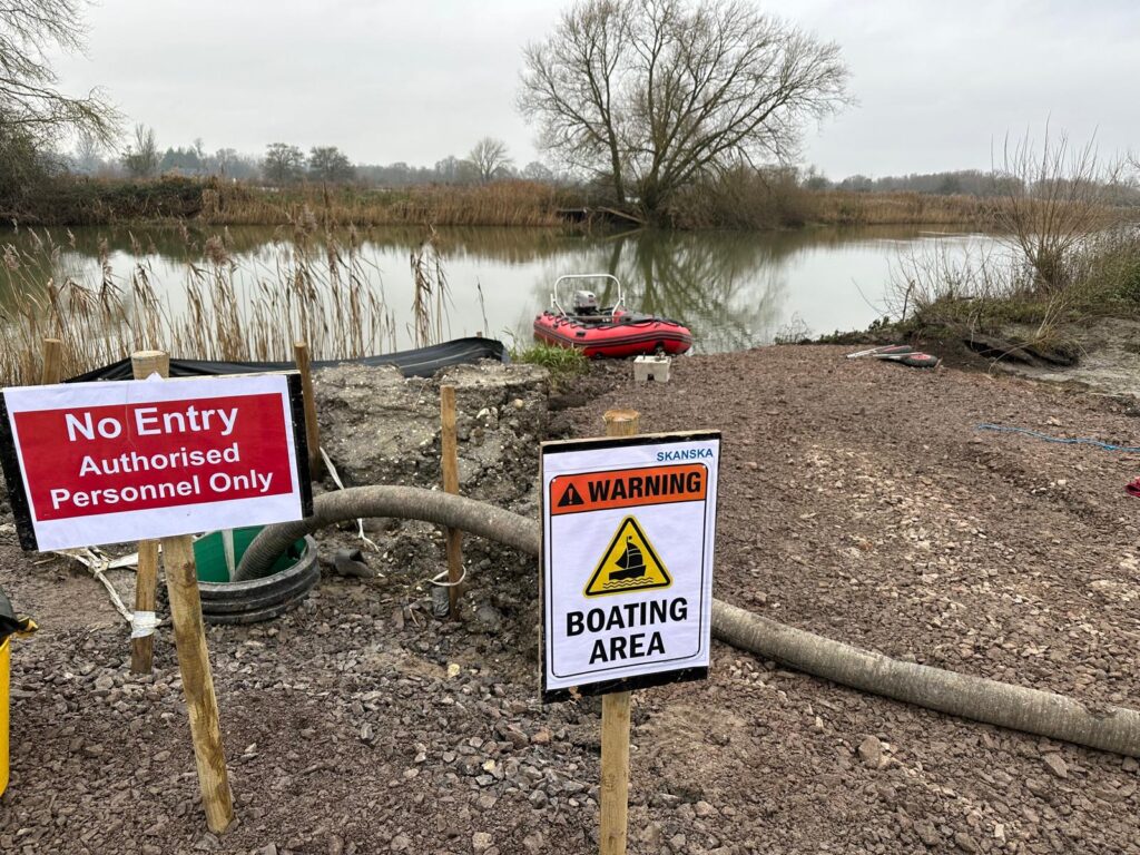 No entry and boating area warning signs at a safety boat launch point on a river
