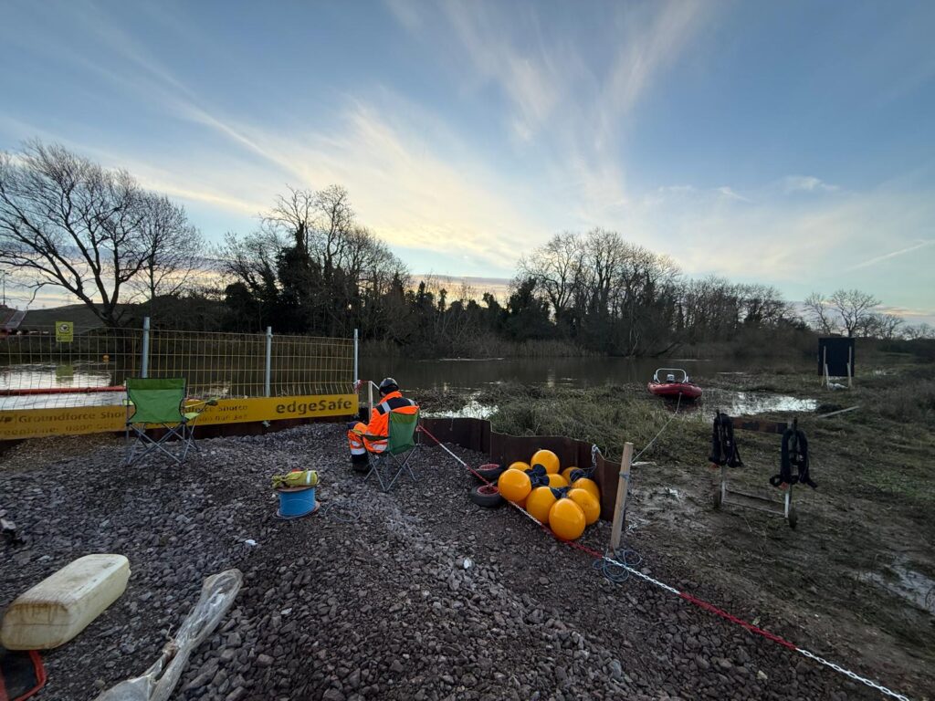 Safety boat standby point on a riverbank with rescue buoys, lifejackets and the boat moored ready